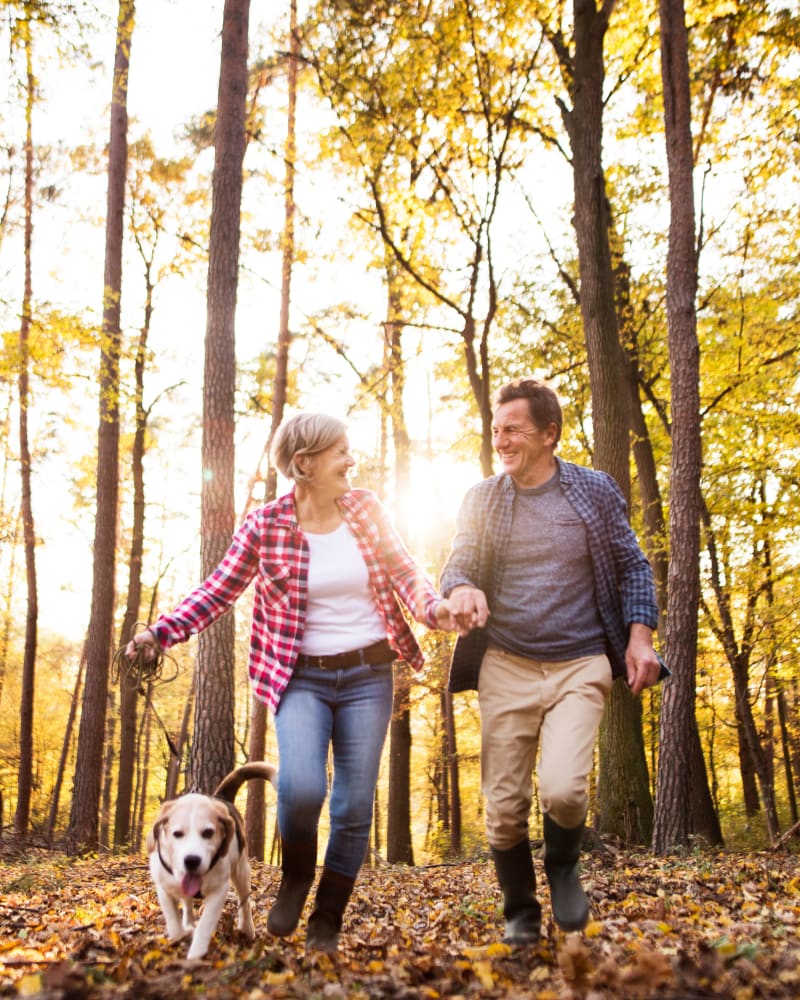 A couple walking their dog through the trees near Residence at Riverside in Austell, Georgia