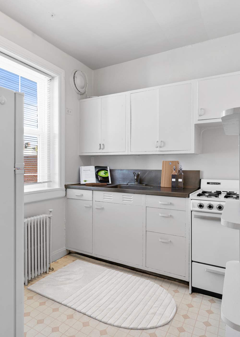 An apartment kitchen with white cabinets at 1005 Grove Ave Apartments in Richmond, Virginia