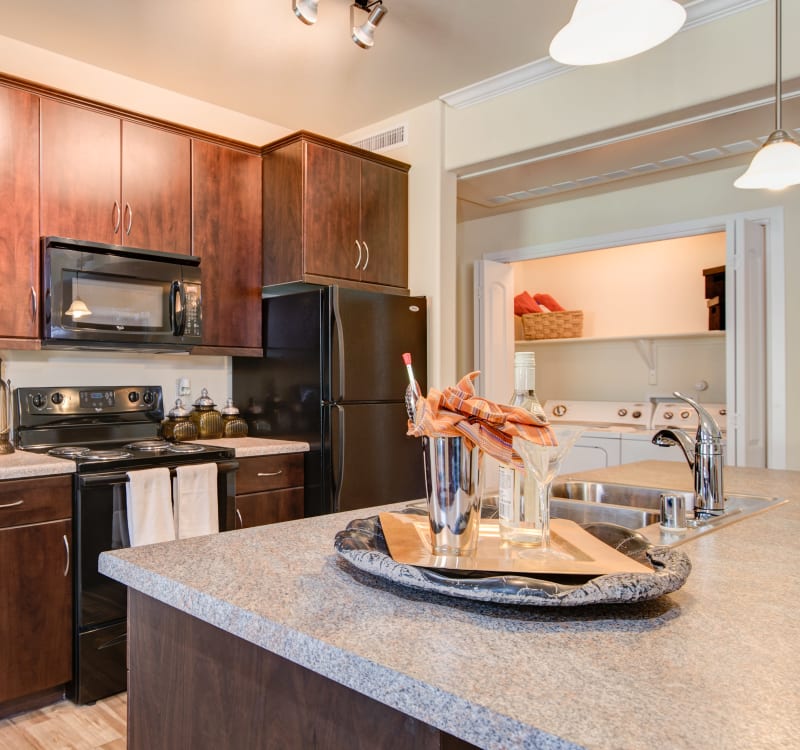 Gourmet kitchen with granite countertops and rich, dark wood cabinetry in a model home at Broadstone Towne Center in Albuquerque, New Mexico