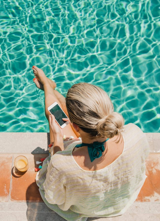 Women FaceTiming at the pool at Slate Ridge at Fisher's Landing Apartment Homes in Vancouver, Washington