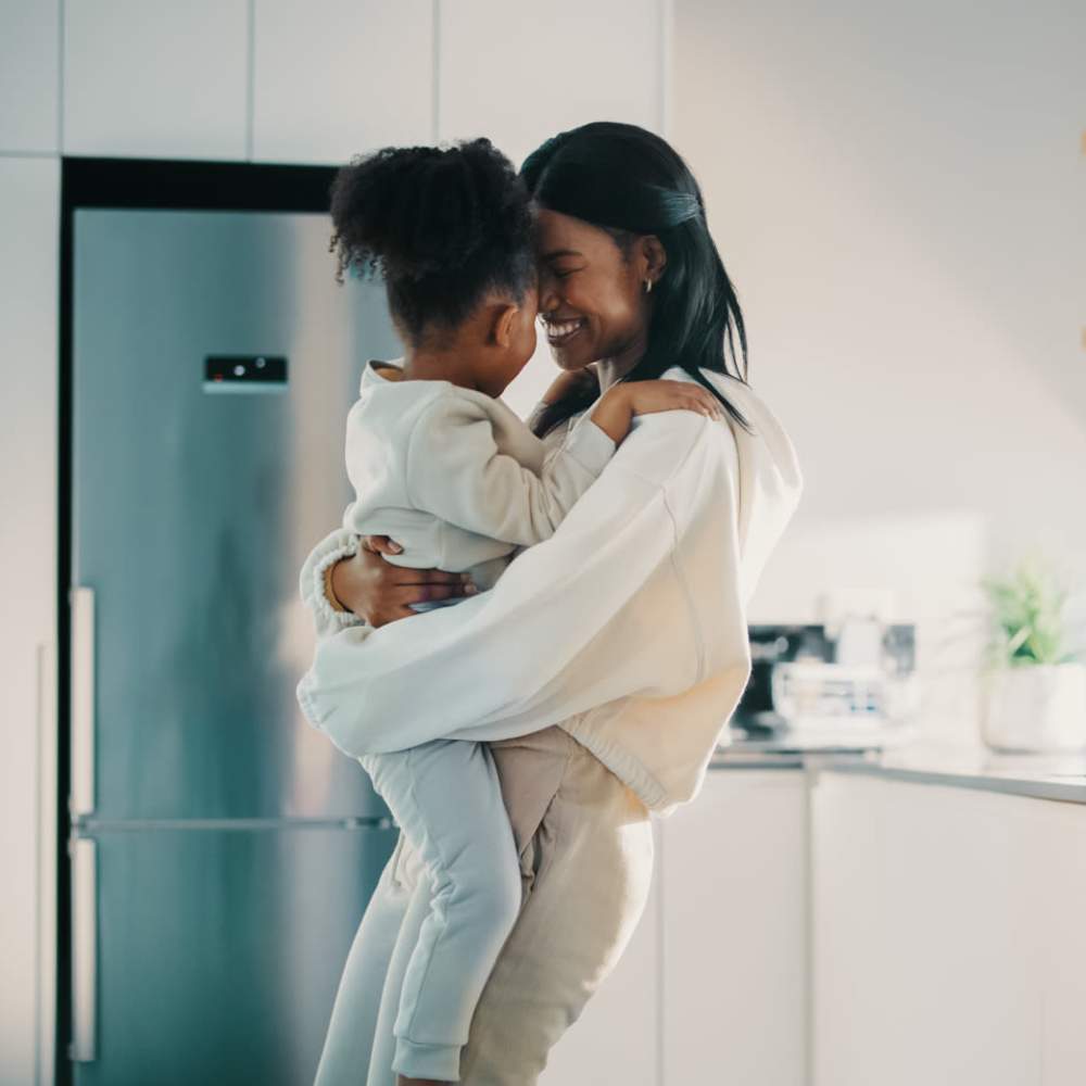Resident playing with her daughter in the modern kitchen at Old Hundred Trace Apartments in Midlothian, Virginia