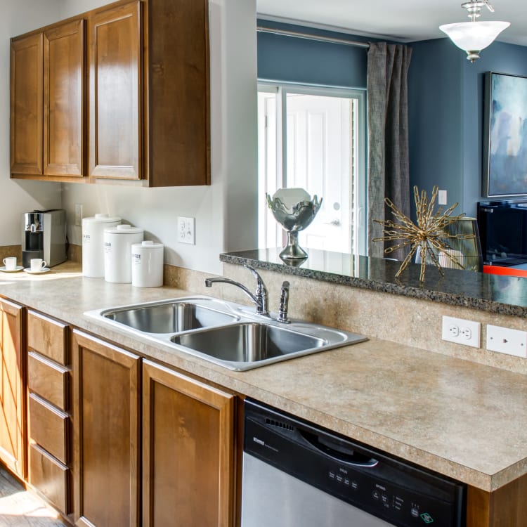 Modern kitchen with granite countertops and a breakfast bar in a model home at Sofi at Cedar Mill in Portland, Oregon