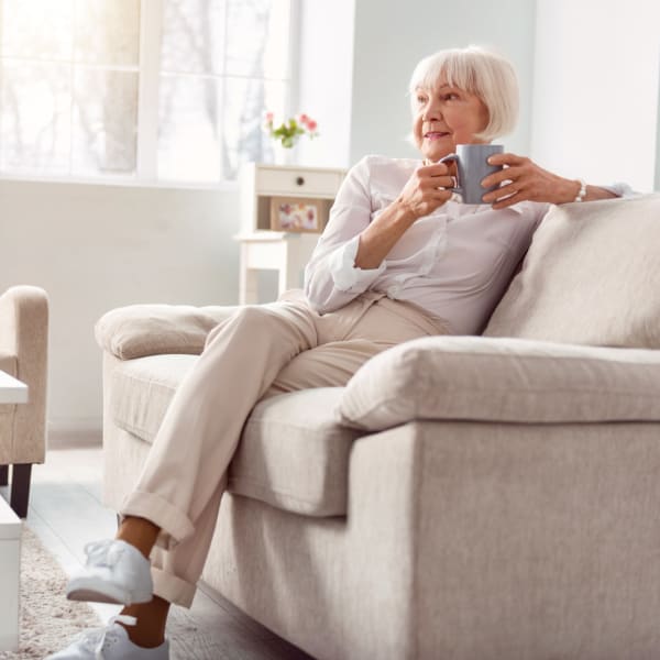 Resident enjoying a coffee in her living room at WellQuest of Granite Bay in Granite Bay, California
