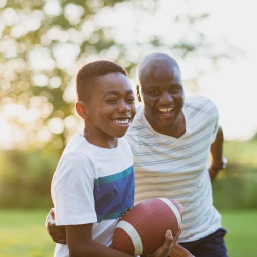 A father and son playing football at Gateway Village in San Diego, California