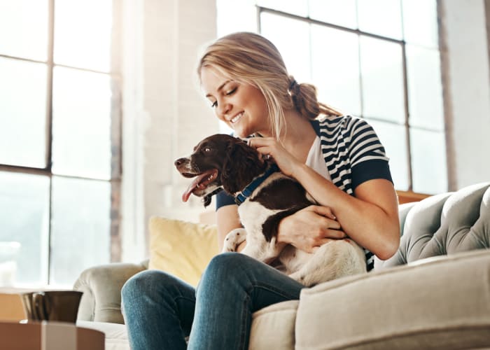 Cute dog and resident sitting on their couch at Ladera in Lafayette, California