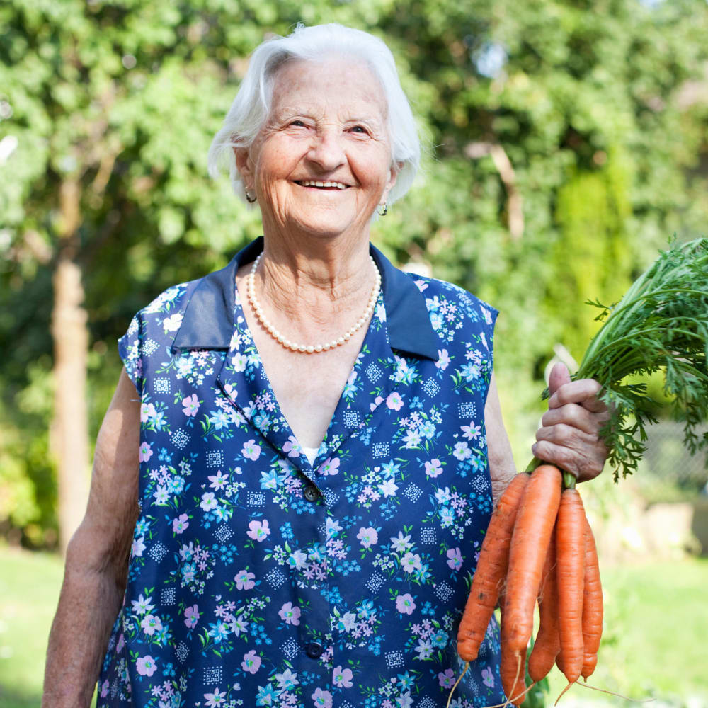 A resident showing off carrots freshly picked from the garden at The Ridge at Lapeer in Lapeer, Michigan