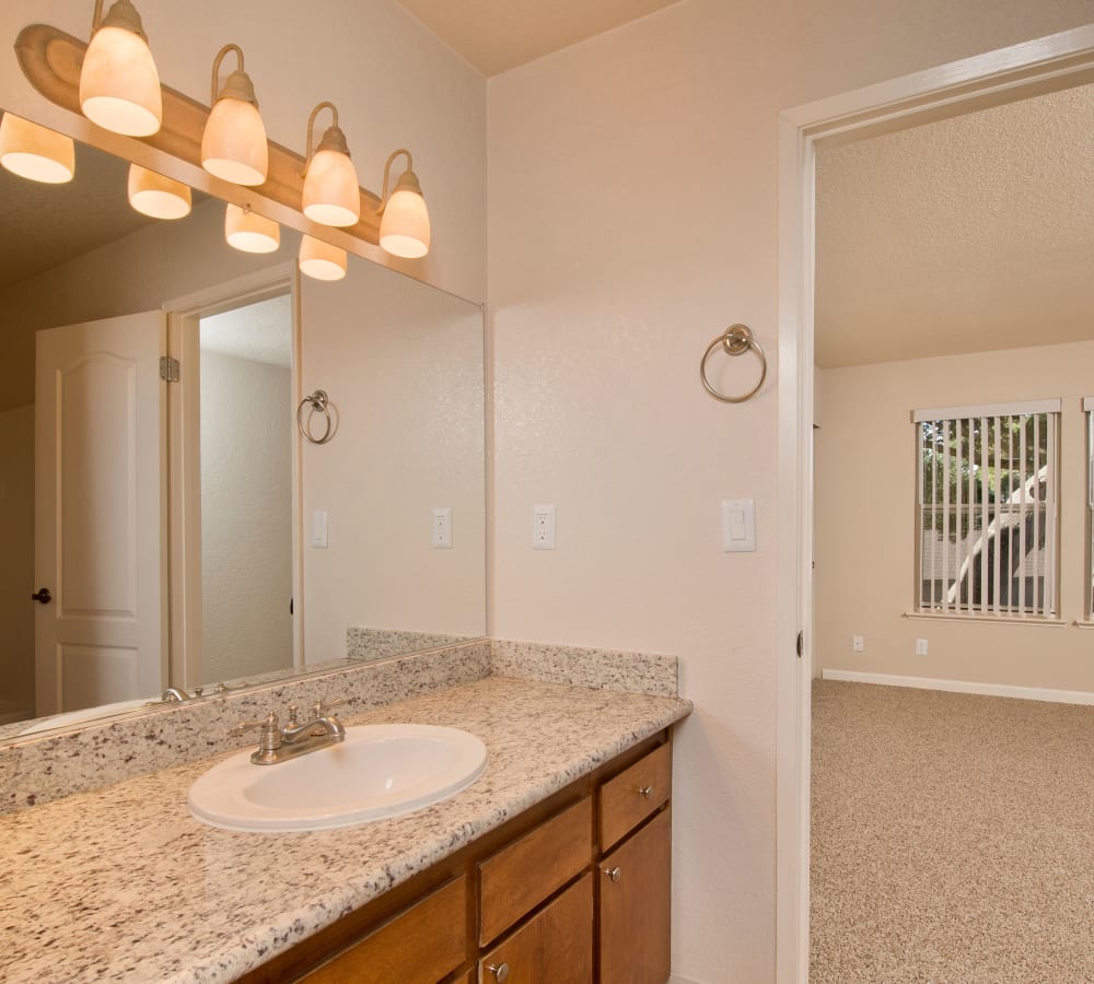 Master bathroom with a large vanity mirror at Seventeen Mile Drive Village Apartment Homes in Pacific Grove, California