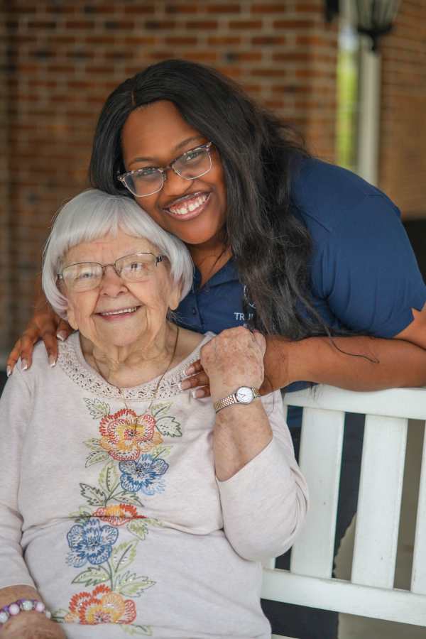 Resident sitting outside with a care giver at Merrill Gardens in Seattle, Washington
