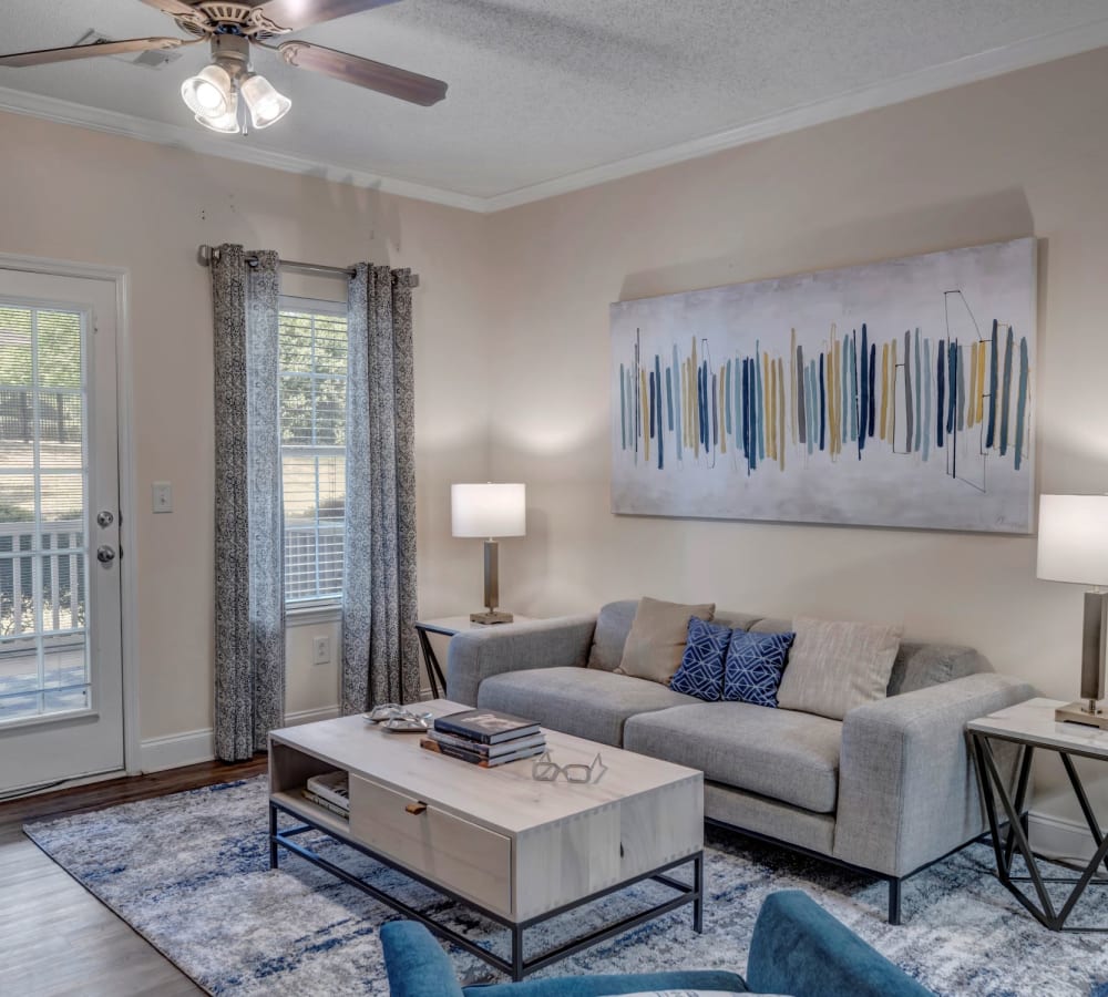 A spacious apartment living room with the kitchen in the background at Adrian On Riverside in Macon, Georgia