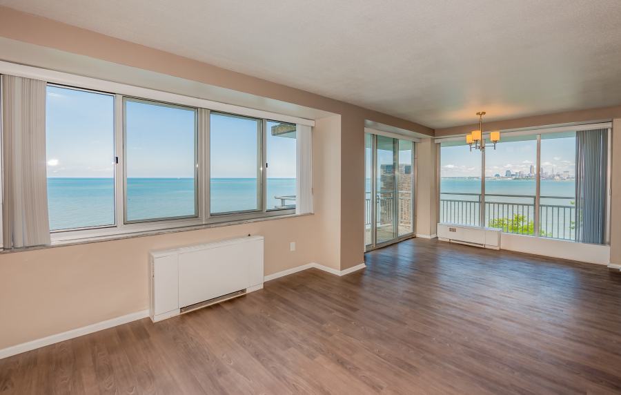 Unfurnished living room with ac units, wood-style flooring and large windows at 12000 Edgewater in Lakewood, Ohio