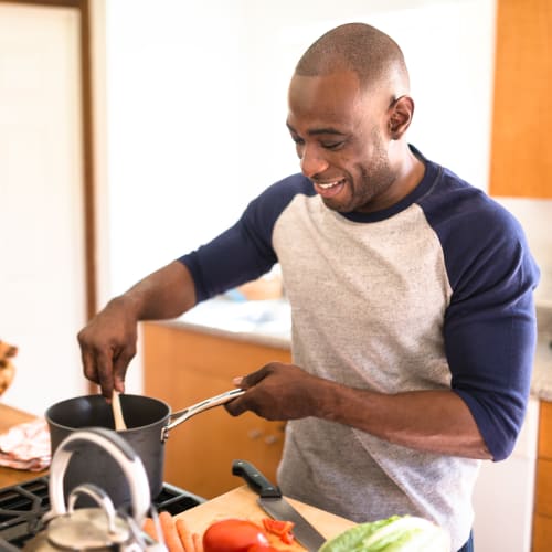 A resident cooking in kitchen at Hamilton Redoubt in Newport News, Virginia