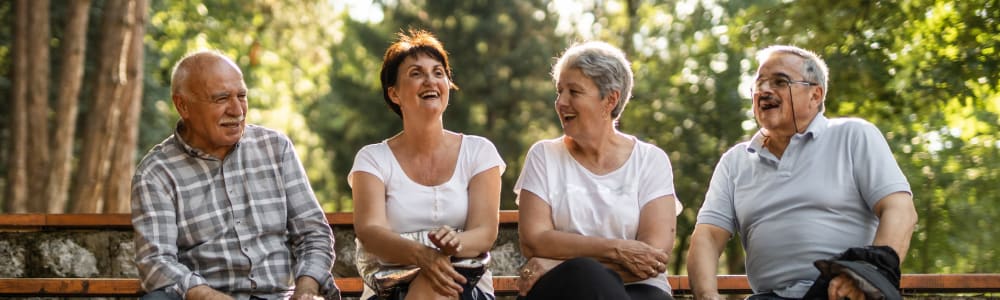 Resident couples sitting outdoors and laughing together