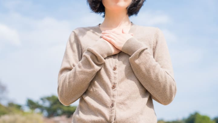 Woman with her hands over her heart in a symbol of gratitude