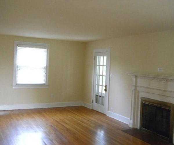 A living room with wood floors and a fireplace at Dahlgren Pointe in Dahlgren, Virginia
