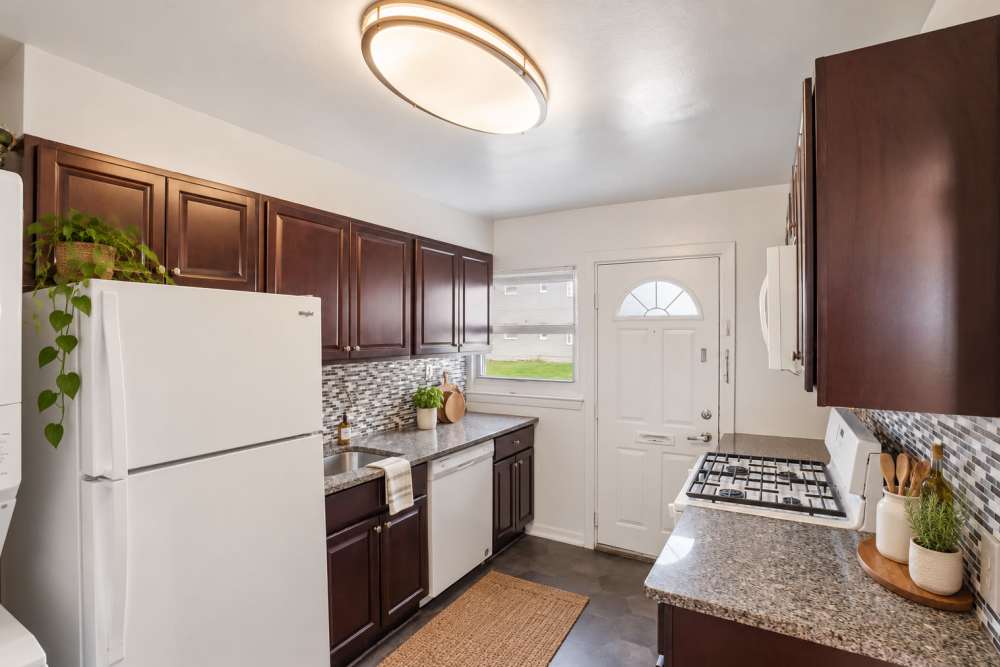 Espresso kitchen with white appliances at apartments in Elmwood Park, New Jersey
