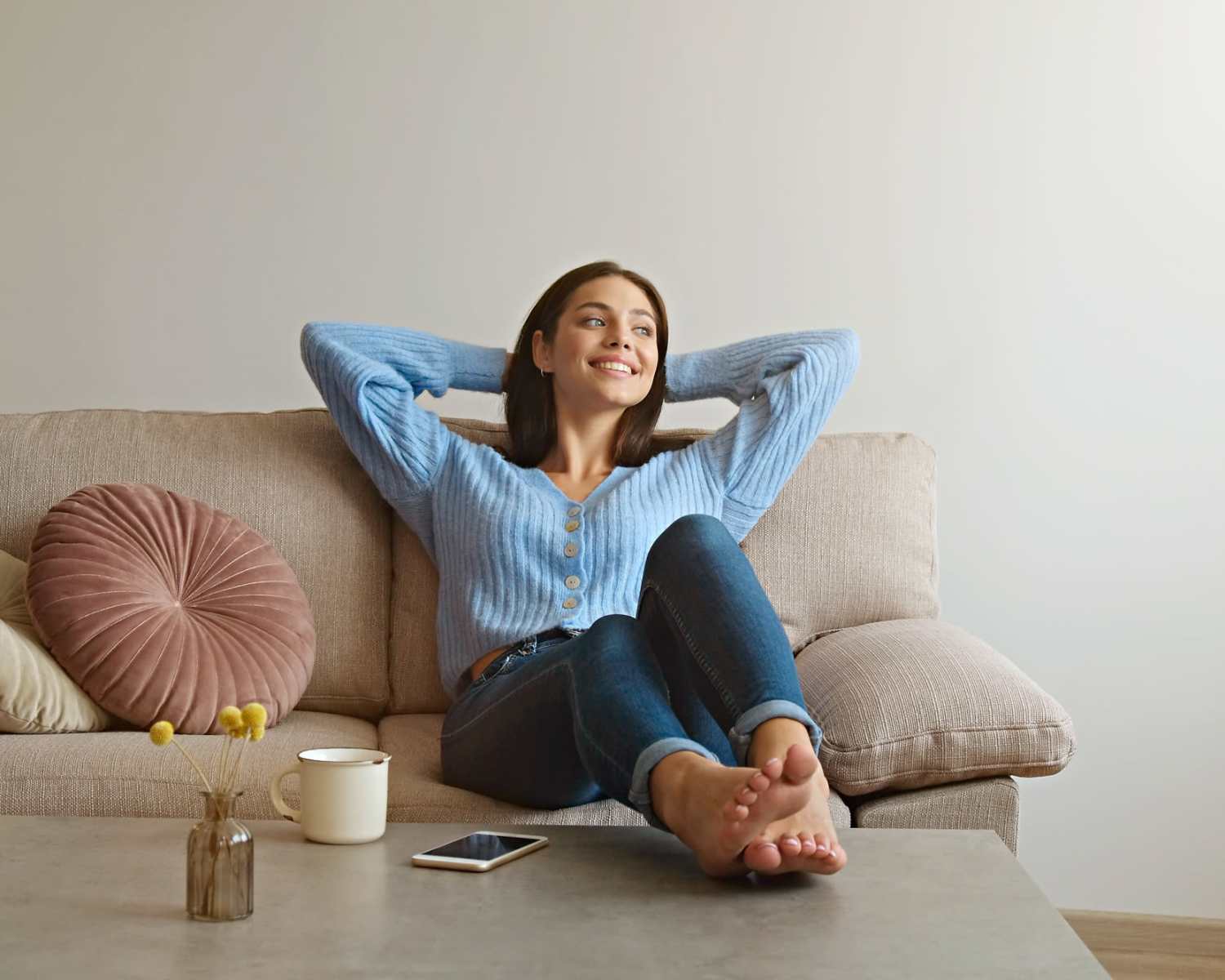 Resident woman relaxing on sofa in her apartment to Flats at Stone Hogan in Atlanta, Georgia