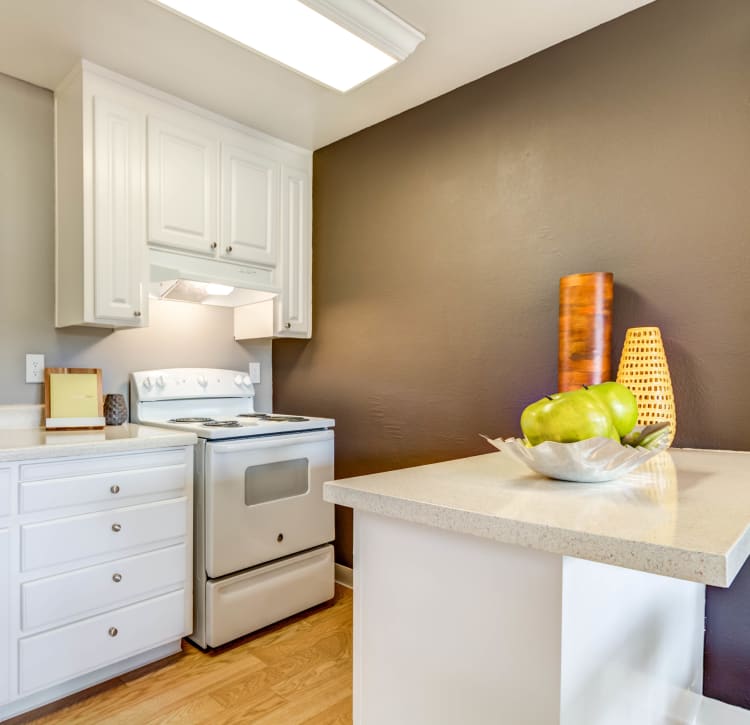 Modern kitchen with a breakfast bar and quartz countertops in a model home at The Landmark Apartment Homes in Sunnyvale, California