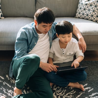 Father and son looking something up online in their apartment at Haven Apartment Homes in Kent, Washington