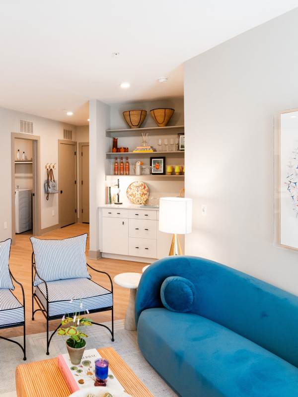 Model apartment living room with two chairs and a blue couch at Platform in Raleigh, North Carolina