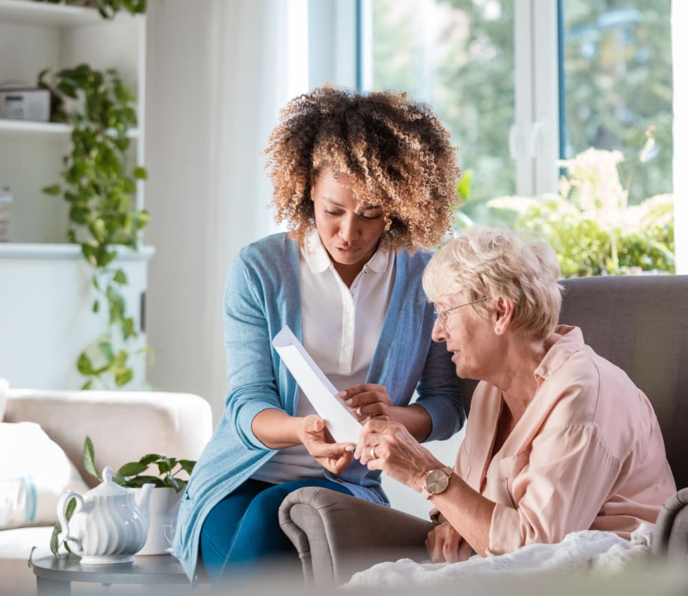 Woman reading with caregiver at Clearwater at North Tustin in Santa Ana, California.