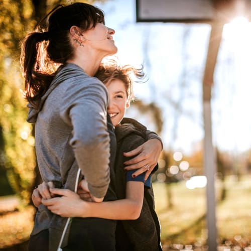 Two residents embracing at a basketball court at Marine Palms in Twentynine Palms, California