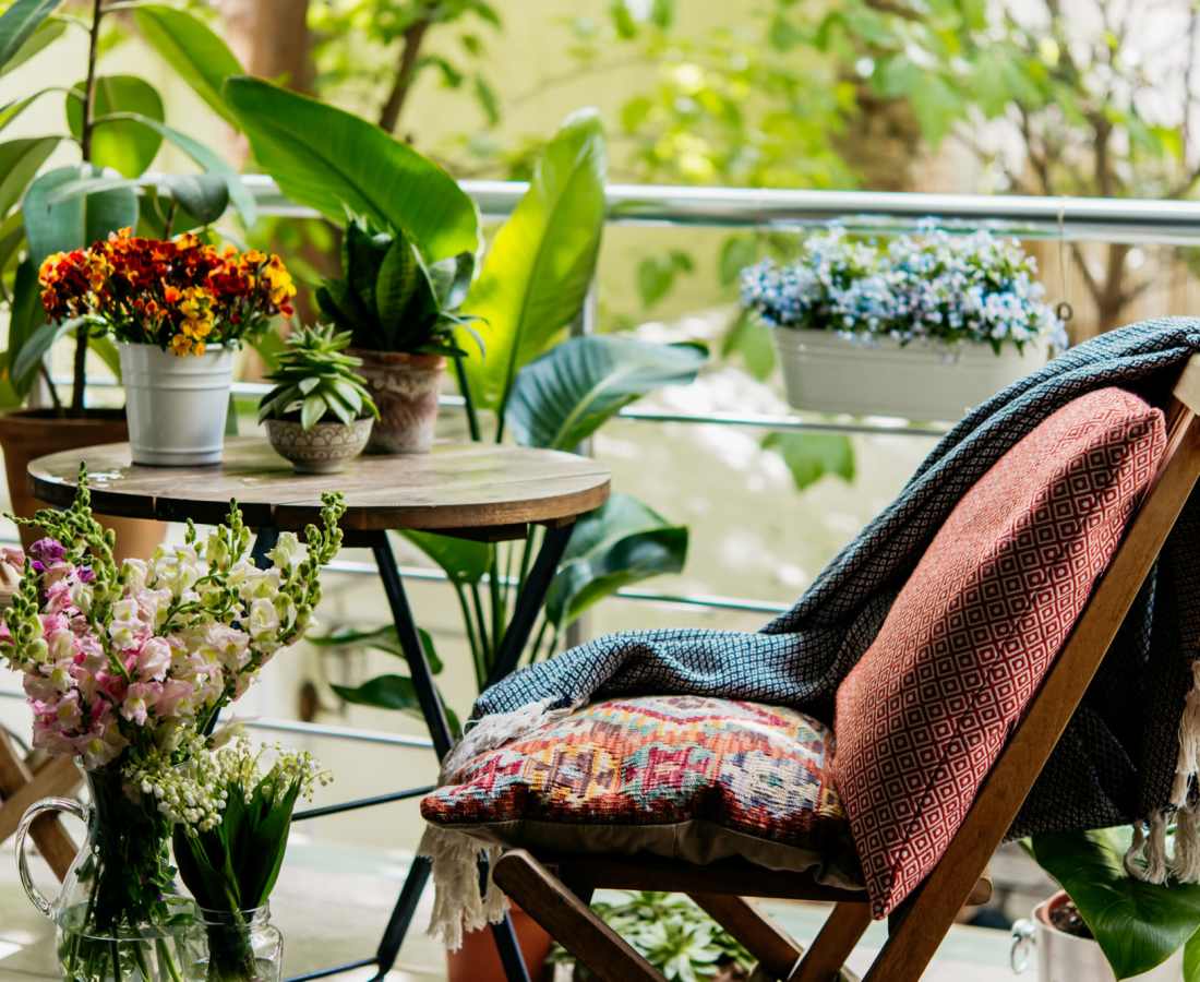 Cozy balcony with plants and seating area at Eagle Ridge Circle in Rochester, New York