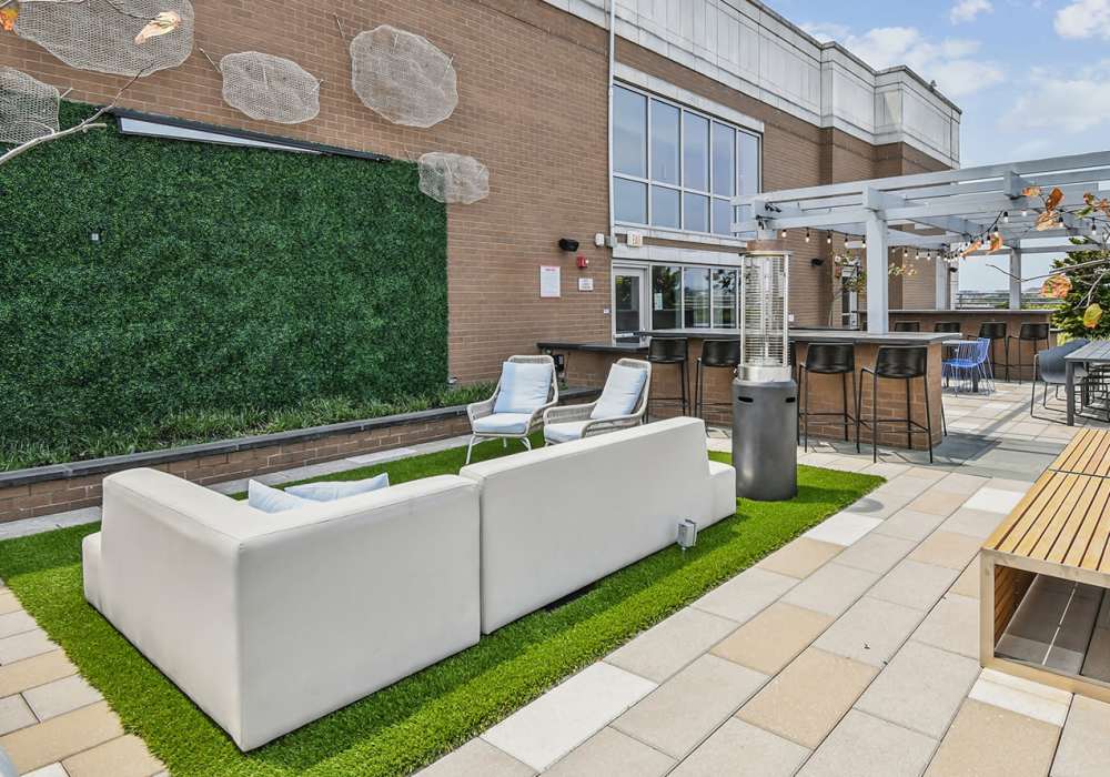 rooftop seating area with green wall and grills