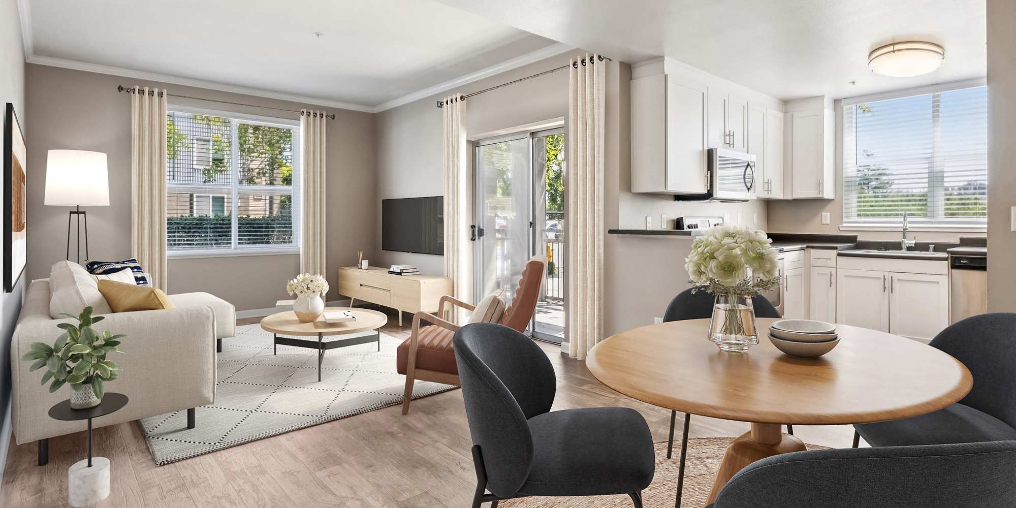 Living room with lots of natural light, dining area, and kitchen with white cabinets and stainless steel appliances at Azure Apartment Homes in Petaluma, California