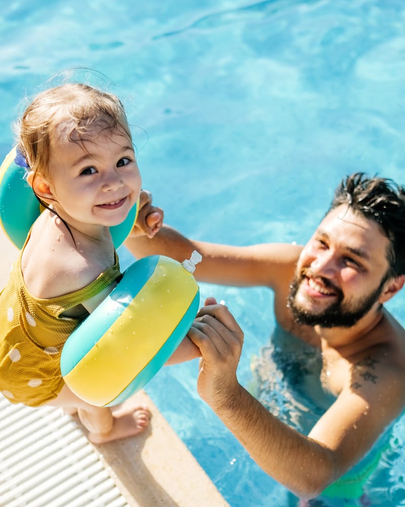 A father helping his child into the swimming pool at The Pines at Peachtree in Columbus, Georgia