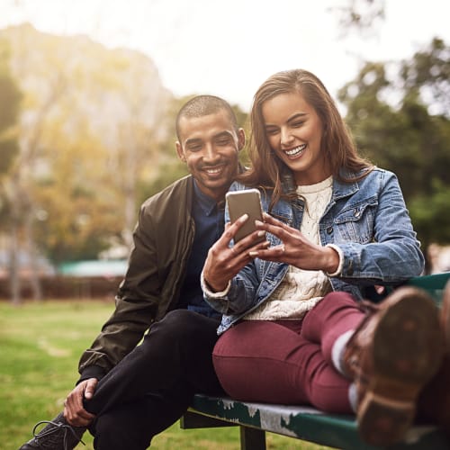 Residents looking at a phone in a park near Eagleview in Joint Base Lewis McChord, Washington