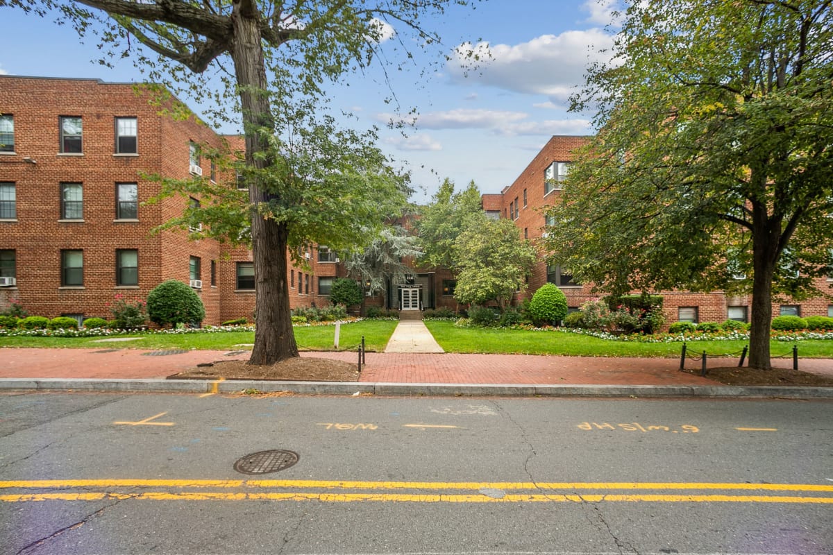 Street view of the large lawn and lots of trees in front of Rock Creek Gardens in Washington, District of Columbia