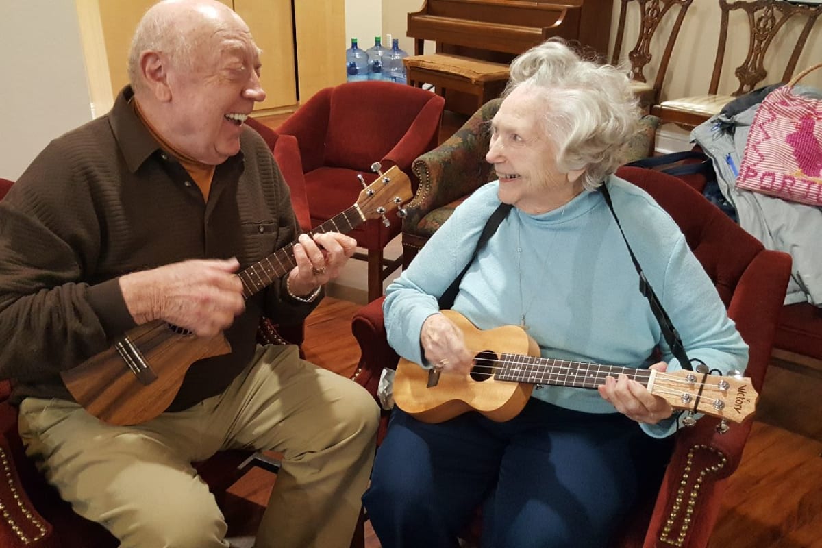 Two happy residents enjoying music at Parsons House Frisco in Frisco, Texas