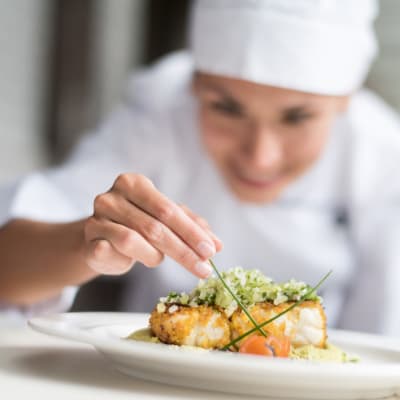 chef putting the finishing touches on a fancy meal at The Sycamore of River Falls in River Falls, Wisconsin