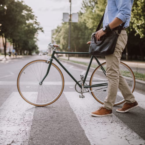 A resident walking a bicycle across the street near Bayview Hills in San Diego, California