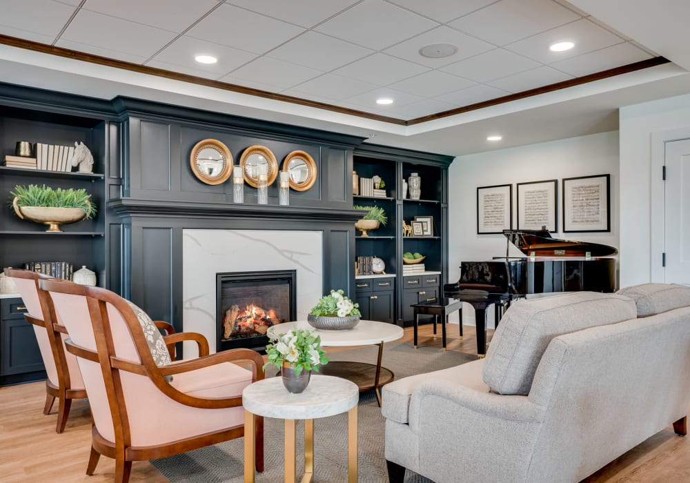 Upscale fireplace lounge with several chairs and a couch arranged around a coffee table at an Amira community