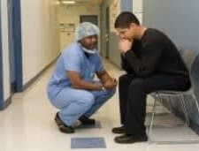 Man sitting in a hospital with a nurse