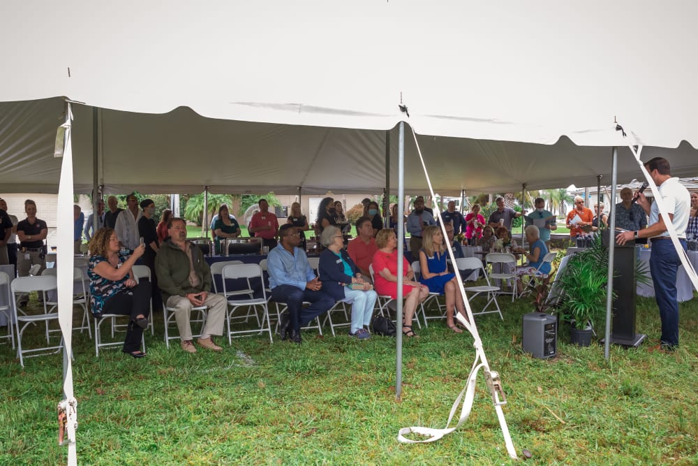 Meridian Senior Living Chief Operating Officer gives speech to event attendees under the tent
