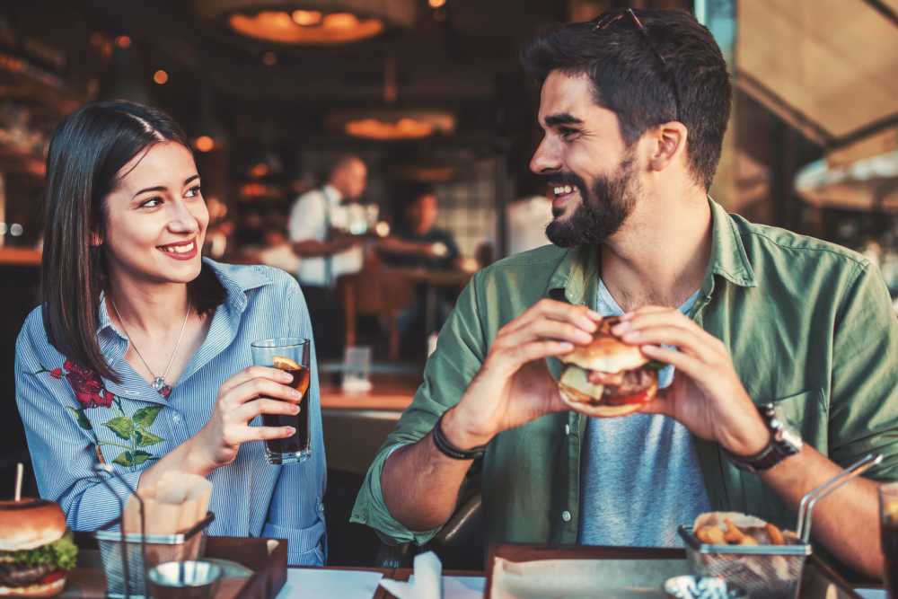A couple enjoying burgers at a restaurant near Copper Square in Lancaster, California