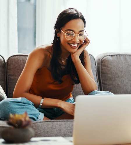A resident woman using her laptop in a living room at Compass Landing in Newport, North Carolina