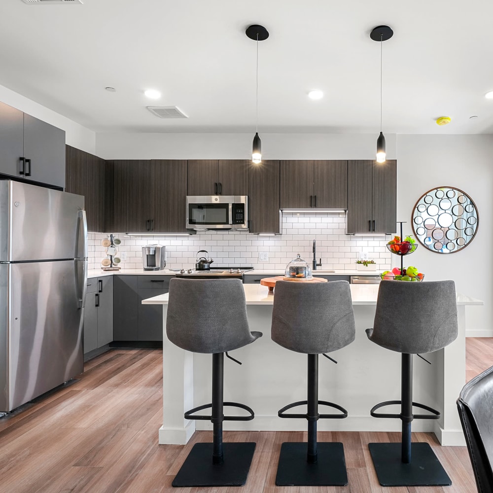Modern kitchen with a subway tile backsplash and stainless-steel appliances in a model luxury home at Anden in Weymouth, Massachusetts