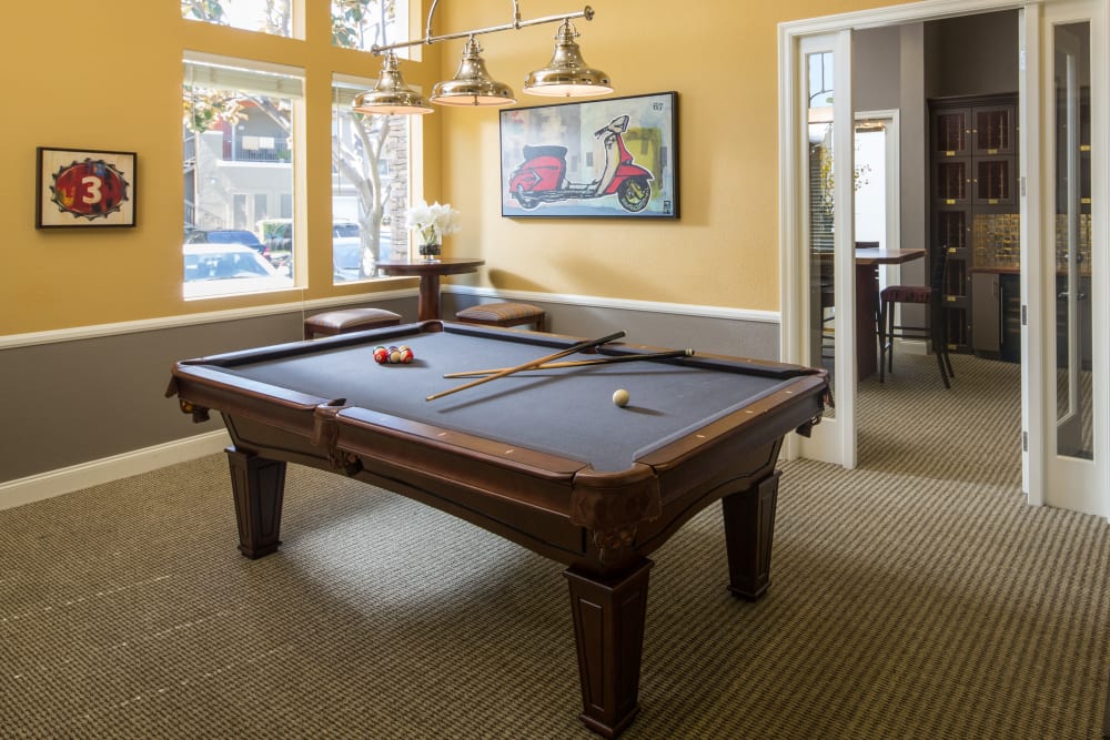 Interior view of the resident clubhouse with a billiards table at Alicante Apartment Homes in Aliso Viejo, California