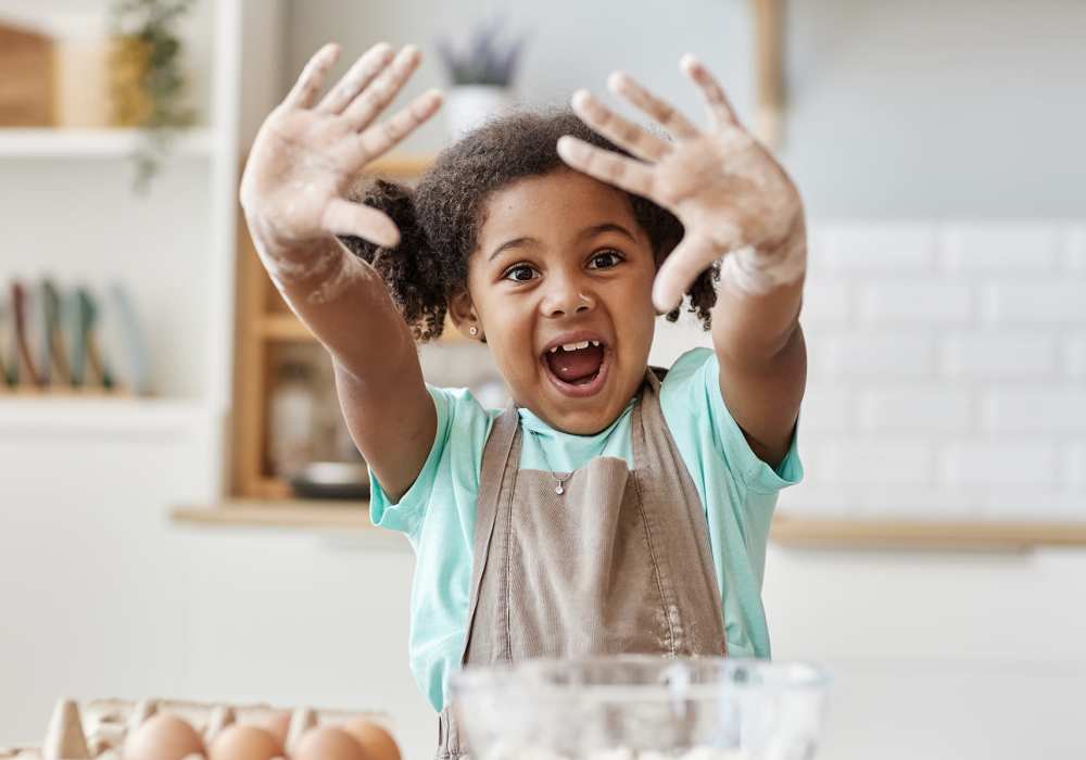 Young child having fun baking in the kitchen at The Avenue at 3060 in Atlanta, Georgia