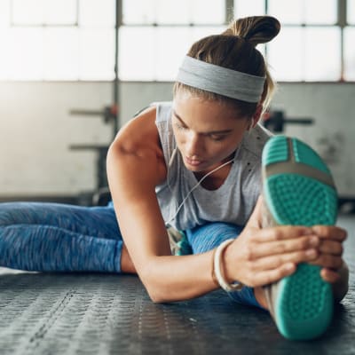 Resident stretching after a workout in the onsite fitness center at Sofi Redwood Park in Redwood City, California