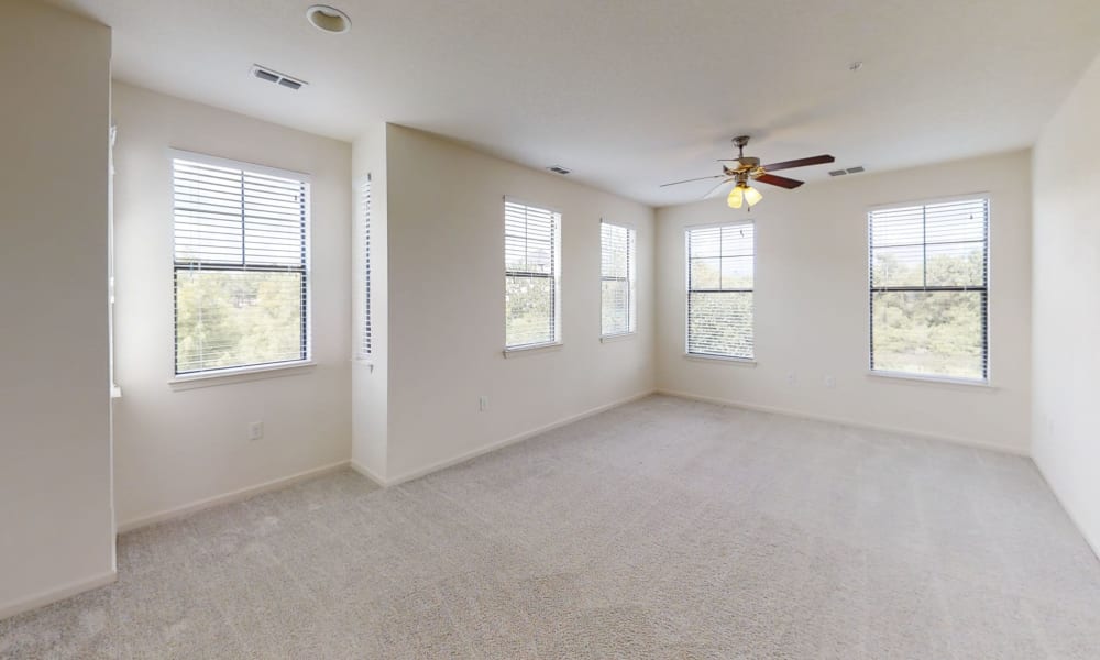 Ceiling fan and plush carpeting in the living area of a model apartment at The Hawthorne in Jacksonville, Florida
