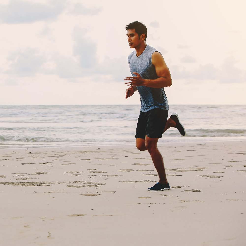 Man running on beach near Jackson Park Terrace in Chicago, Illinois