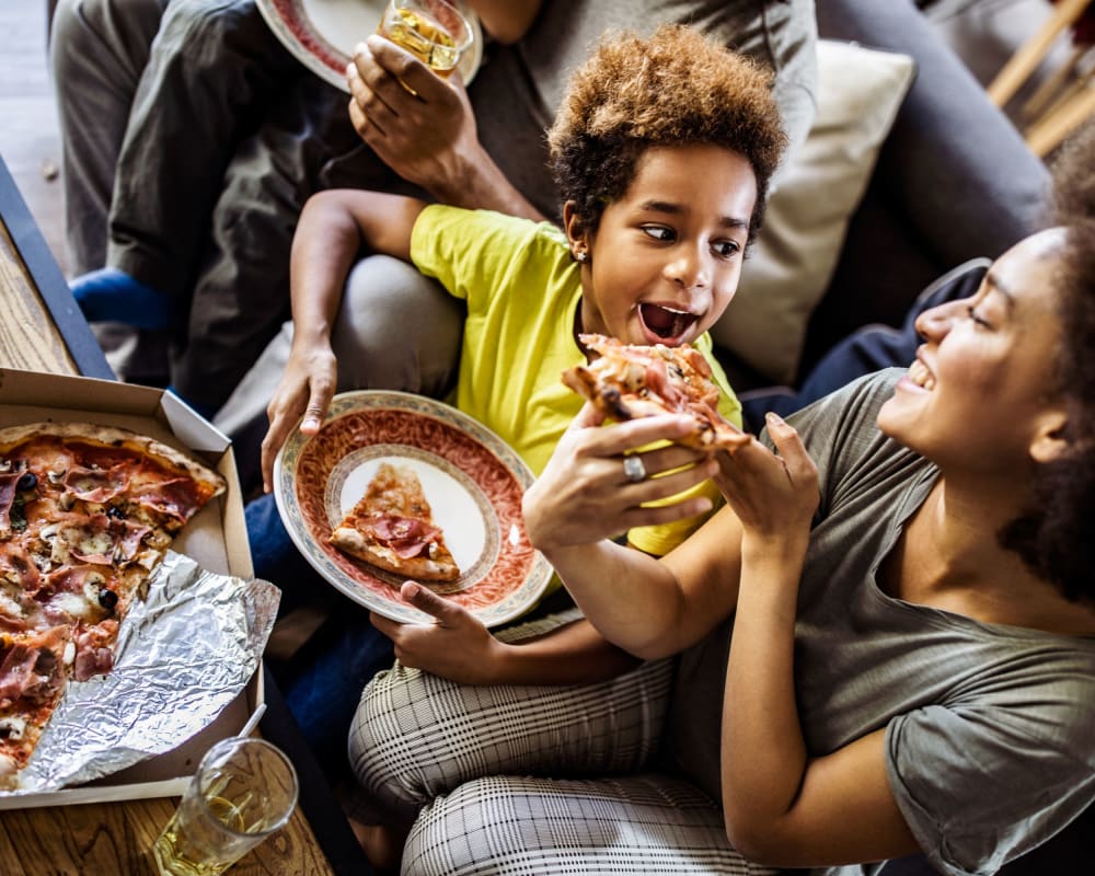 A resident and her child eating pizza near Discovery Village in Joint Base Lewis McChord, Washington