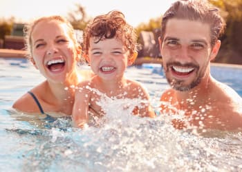 Family smiling in the pool at Ashland Garden in San Lorenzo, California