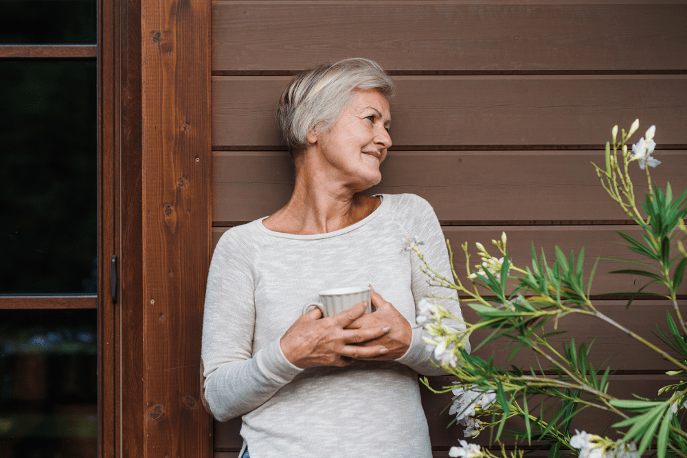 Resident enjoying a hot beverage just outside her home