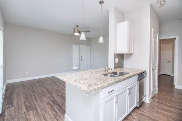 Living and dining area view from kitchen at Green Tree Place in Houston, Texas