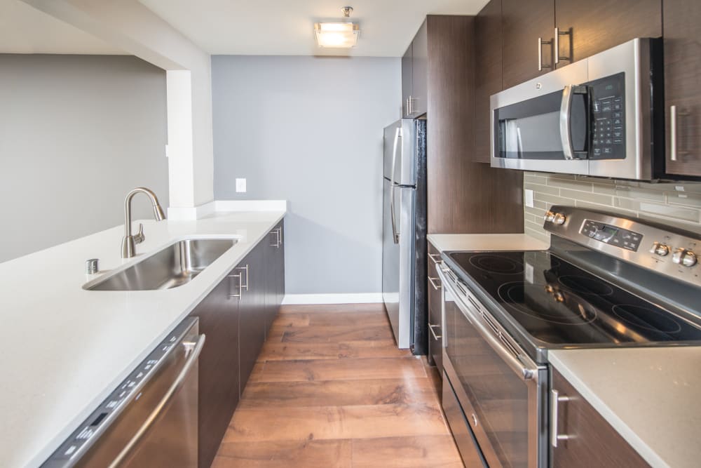 Well equipped kitchen with stainless-steel and wood floors at 2900 on First Apartments in Seattle, Washington